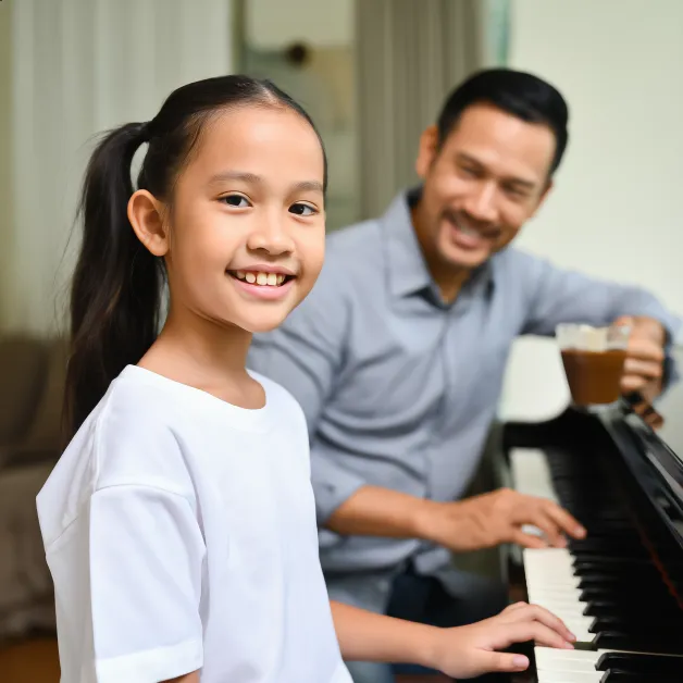 เด็กหญิงเล่นเปียโนกับพ่อ ดนตรีสร้างสายสัมพันธ์ในครอบครัวและช่วยให้เด็กเรียนรู้การฟังและความพยายามอย่างอ่อนโยน
